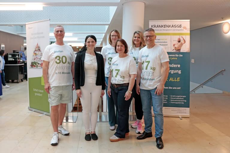 Sechs Personen in weißen T-Shirts mit Gewichtsverlust-Statistiken vor Krankenkassen-Bannern